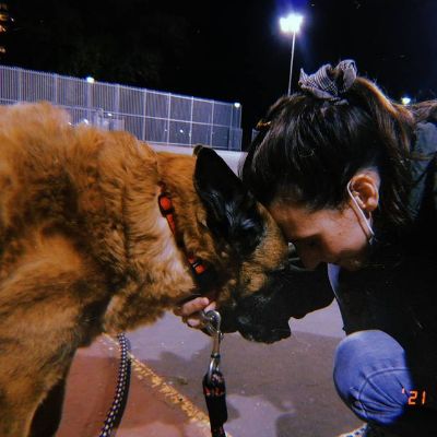 Ortal Ben-Shoshan and the dog are touching each other's head.